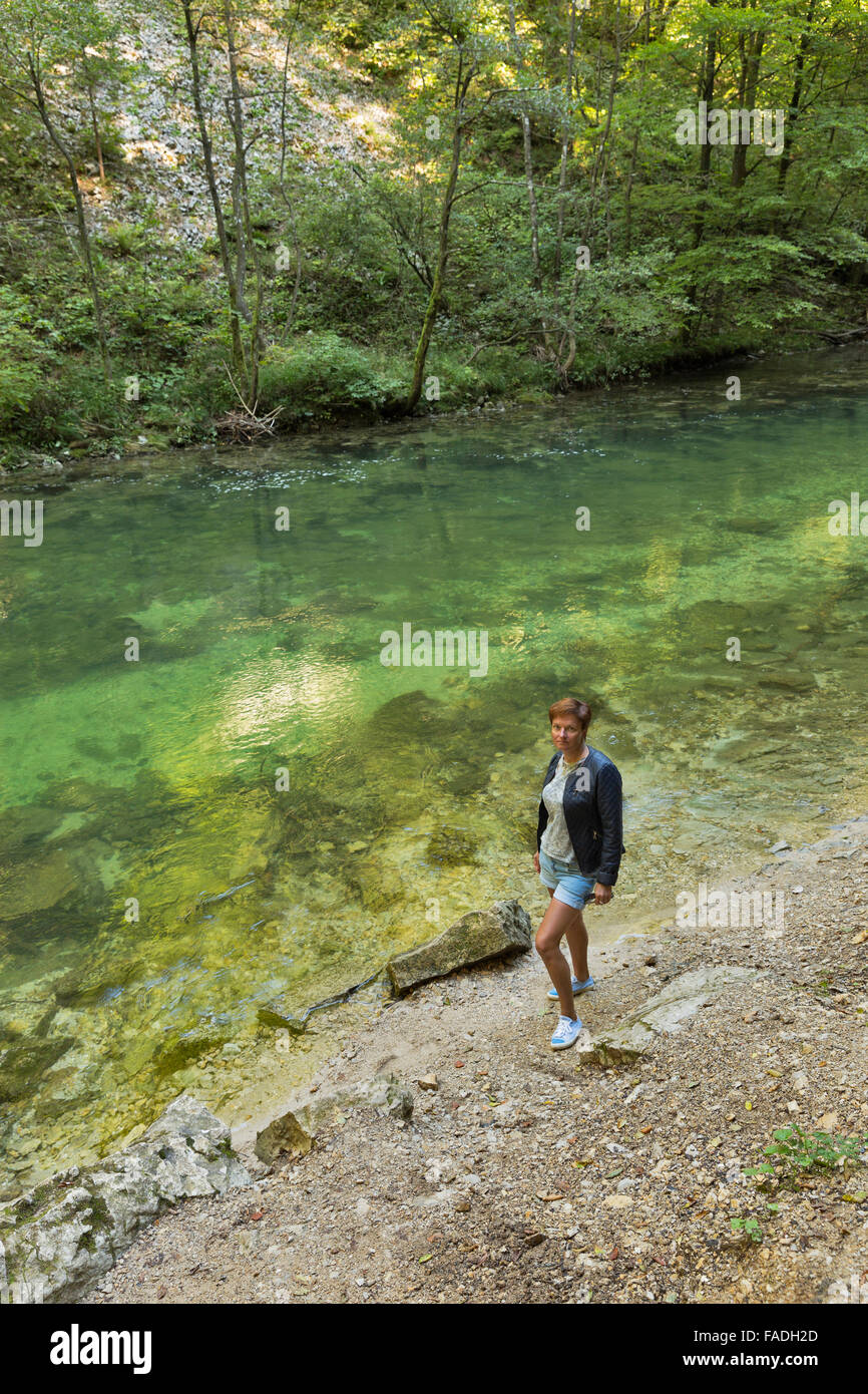 Portrait femme bronzée se dresse sur la rive de la rivière Radovna dans gorges de Vintgar. Bled, Slovénie. Banque D'Images