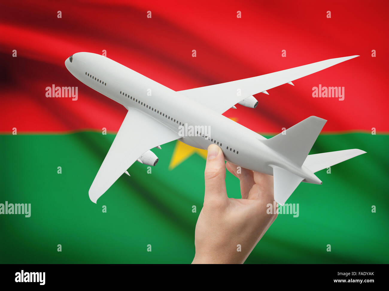 Avion en main avec drapeau national sur l'arrière-plan - Burkina Faso Banque D'Images