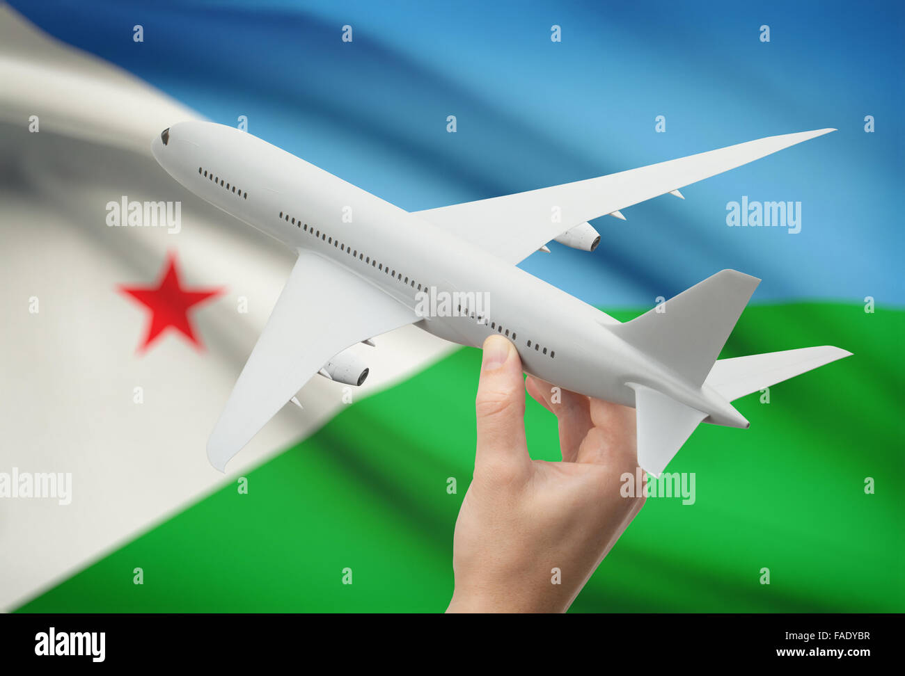 Avion en main avec drapeau national sur l'arrière-plan - Djibouti Banque D'Images