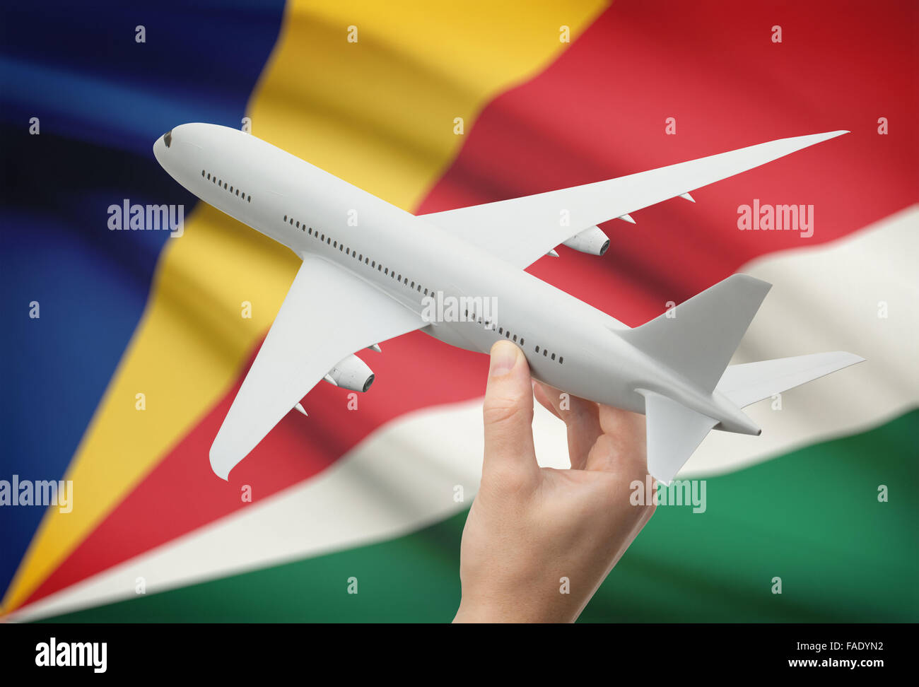 Avion en main avec drapeau national sur l'arrière-plan - Seychelles Banque D'Images