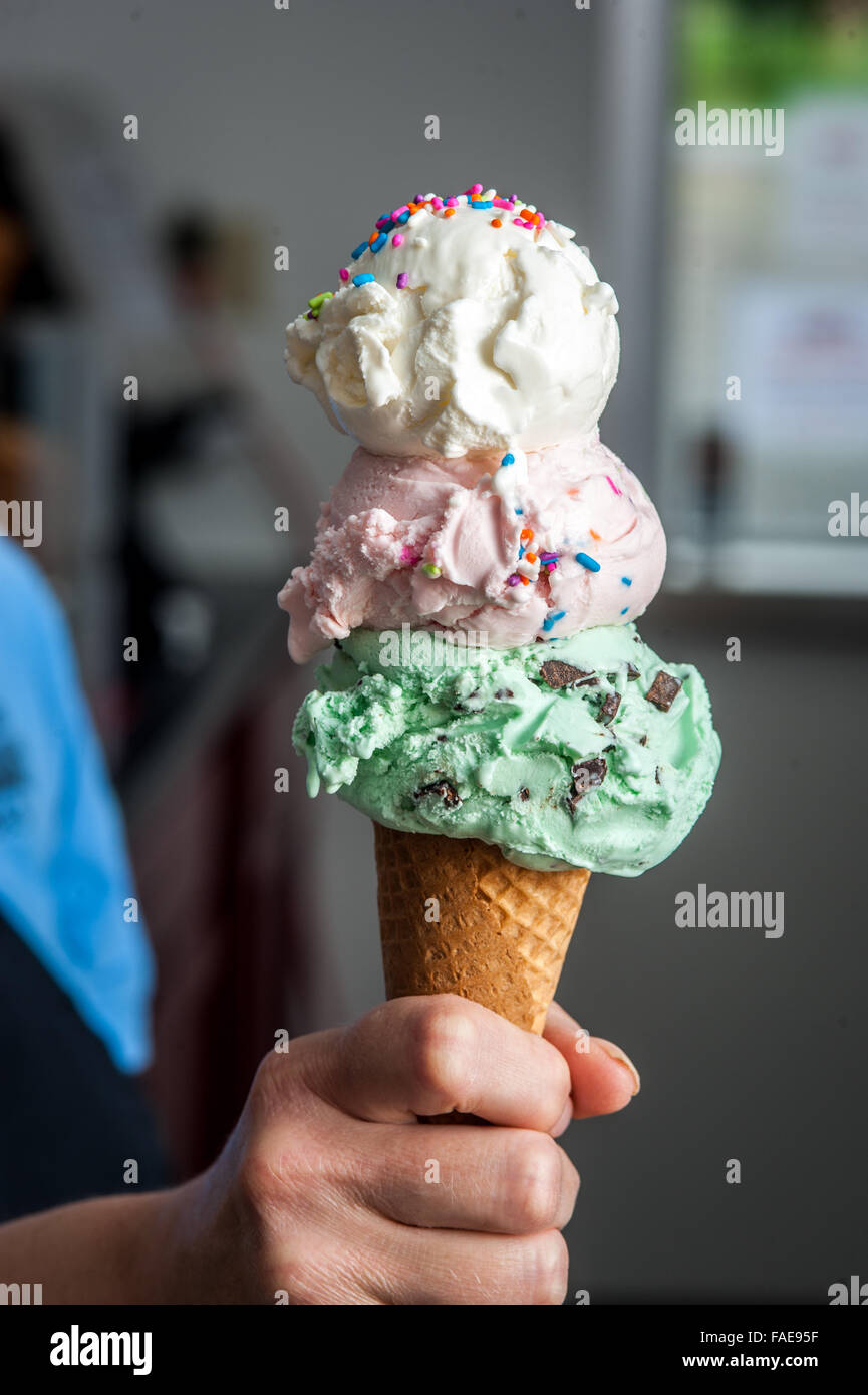 Hand holding a raflé trois ice cream cone Banque D'Images