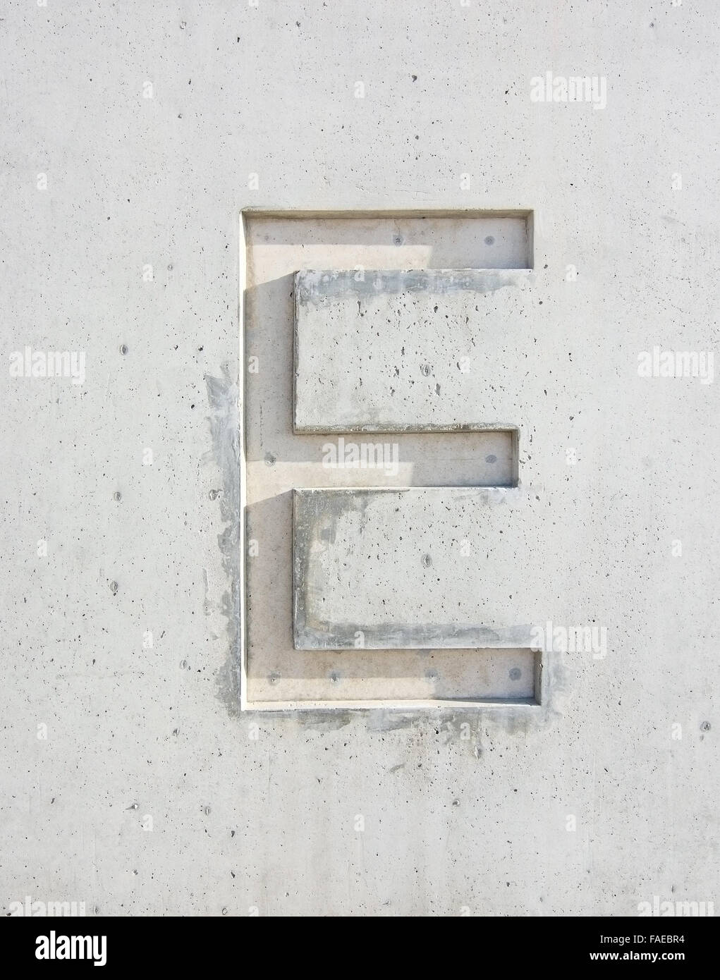 La lettre 'E' coupé en pierre blanche grisâtre de l'élément de conception Banque D'Images