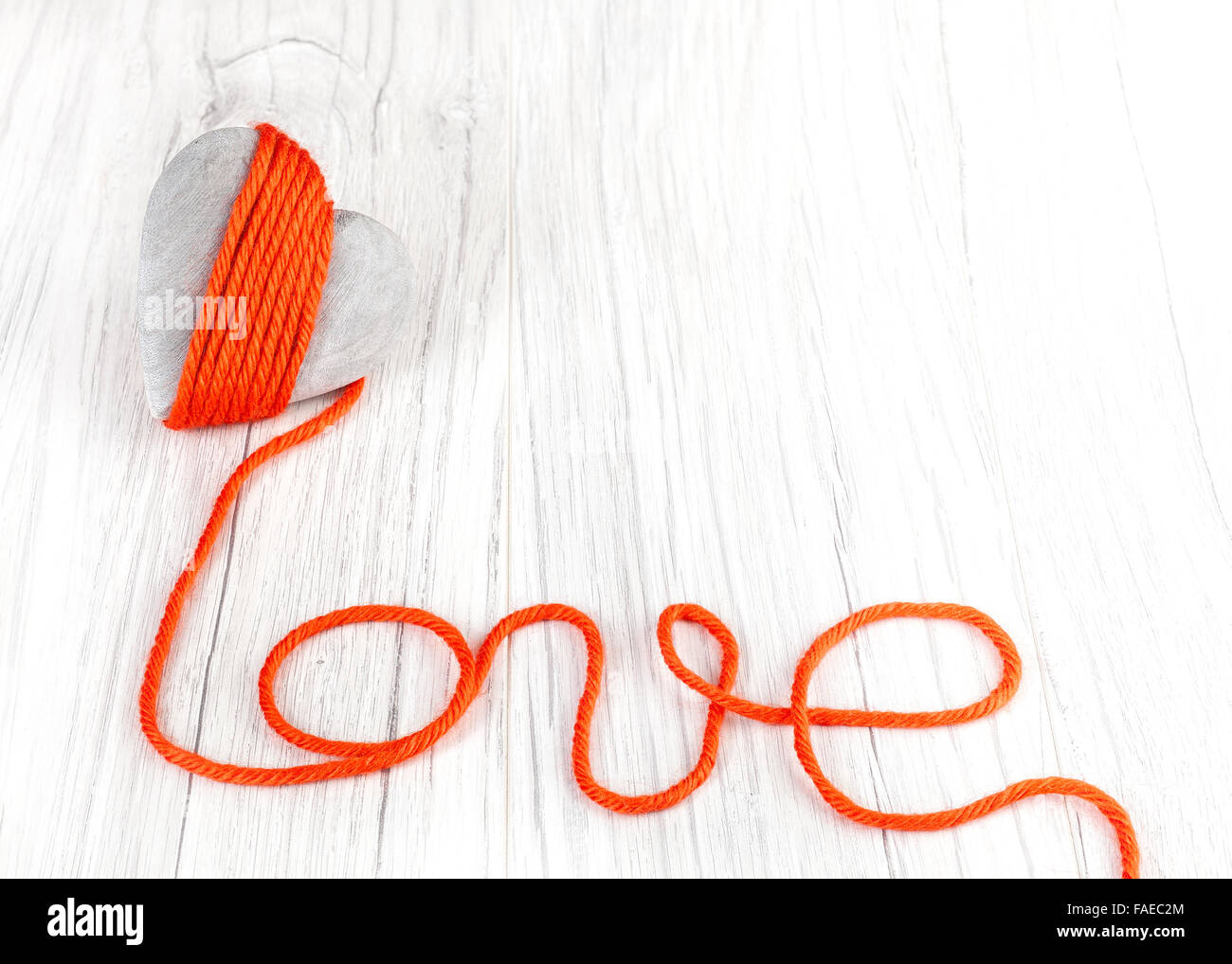 Coeur en bois avec fil rouge signe d'amour, de l'espace pour le texte. Banque D'Images