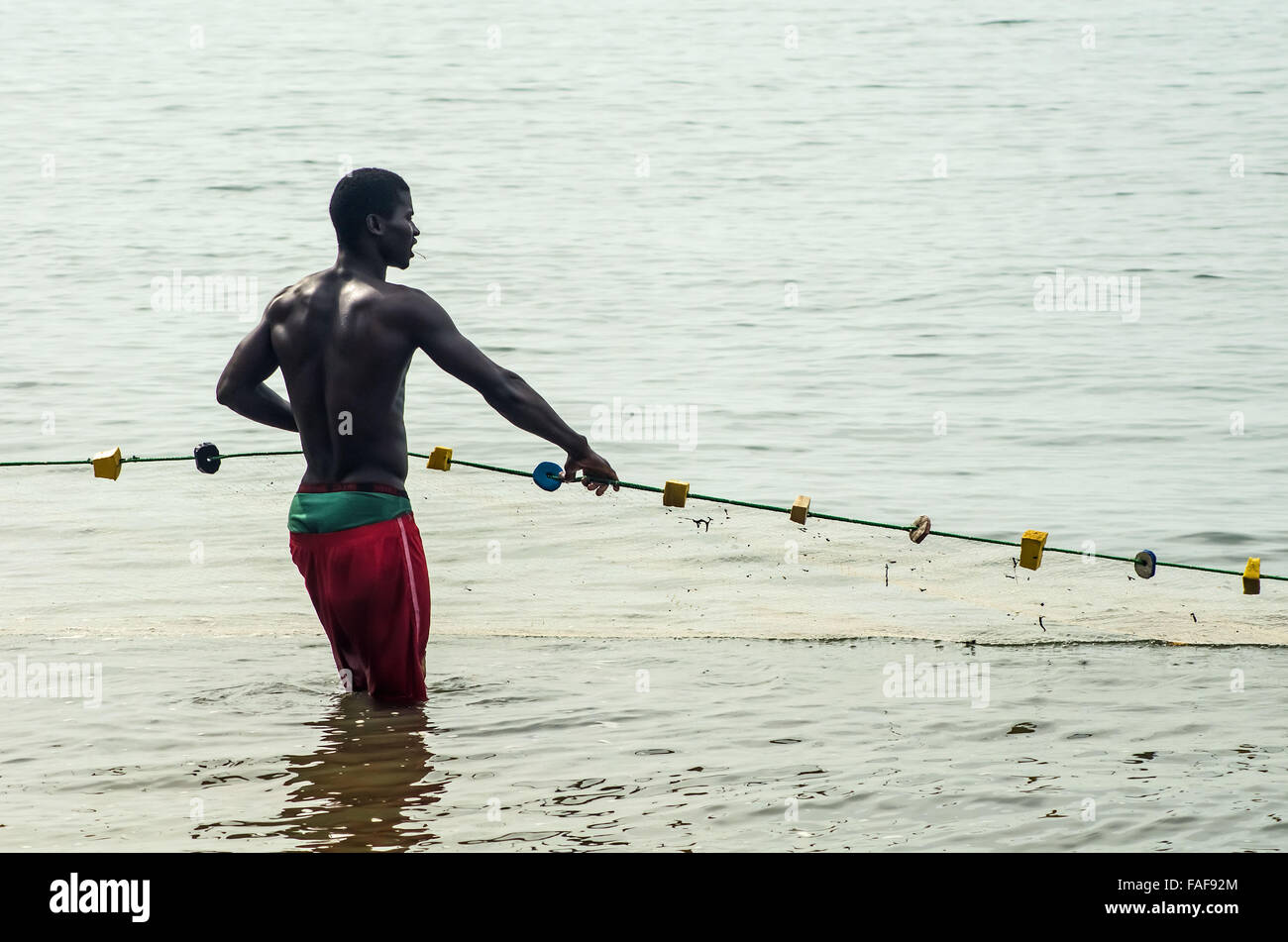 Un pêcheur tire dans ses prises sur une plage en Sierra Leone, population des îles. Banque D'Images