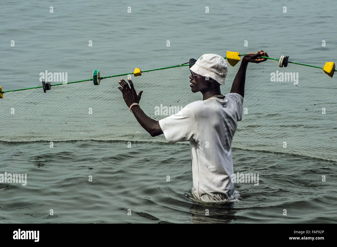 Un pêcheur tire dans ses prises sur une plage en Sierra Leone, population des îles. Banque D'Images
