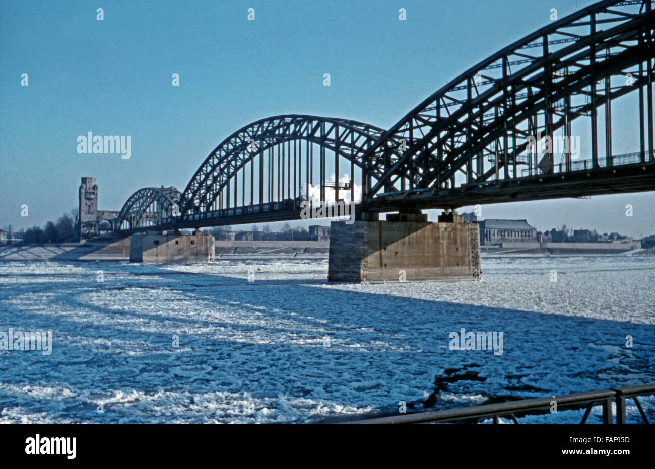 Eisschollen treiben Hohenzollernbrücke unter der auf dem Rhein à Köln mit Deutz, Deutschland 1950er Jahre. Des plaques de glace flottant sur Rhin dans Hohenzollernbruecle pont à Cologne avec vue de Deutz, l'Allemagne des années 1950. Banque D'Images