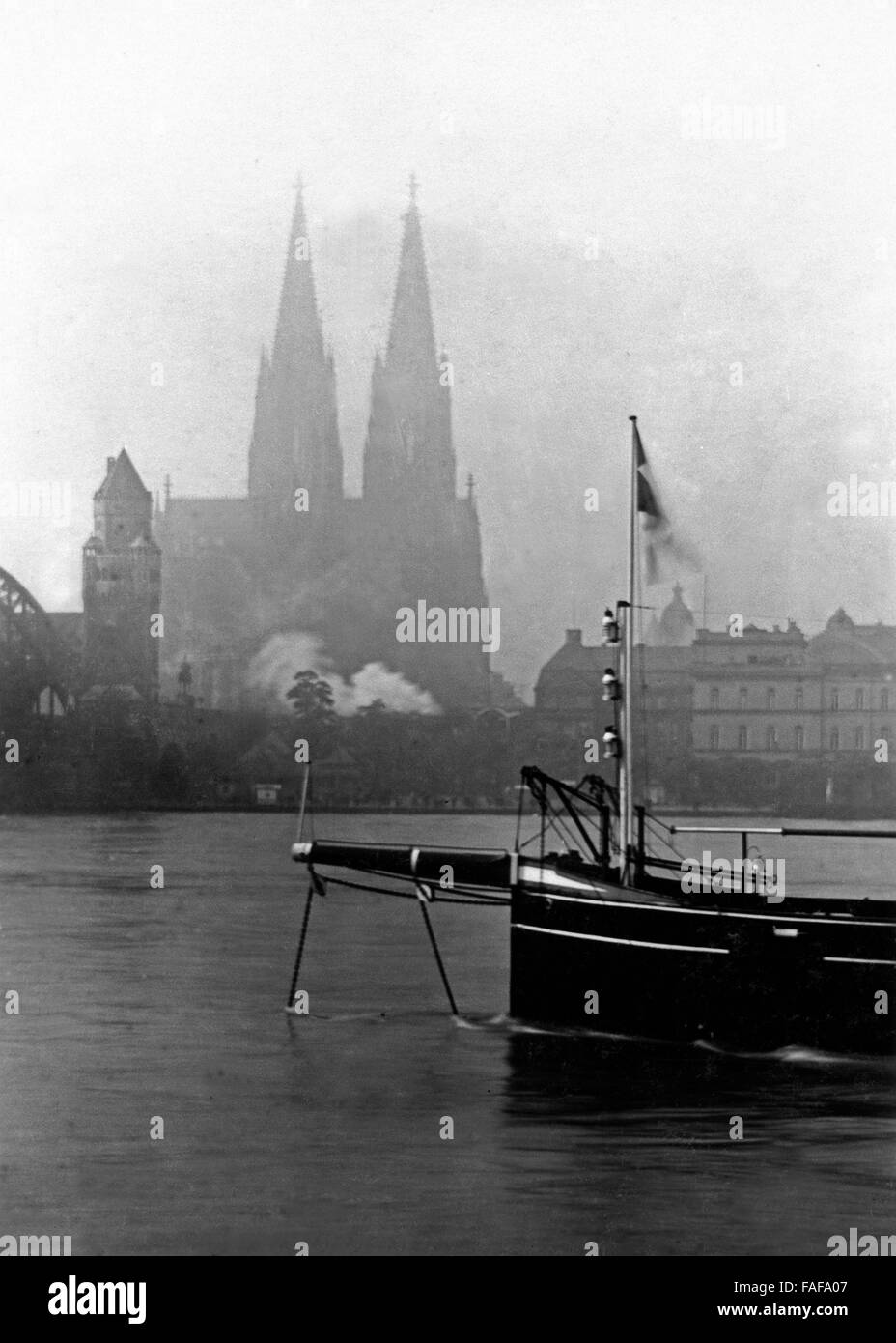 Ein Dampfboot liegt auf dem Rhein vor dem Dom dans Köln, Deutschland 1920er Jahre. Un bateau à vapeur sur l'ancrage Rhin en face de la cathédrale de Cologne, Allemagne 1920. Banque D'Images