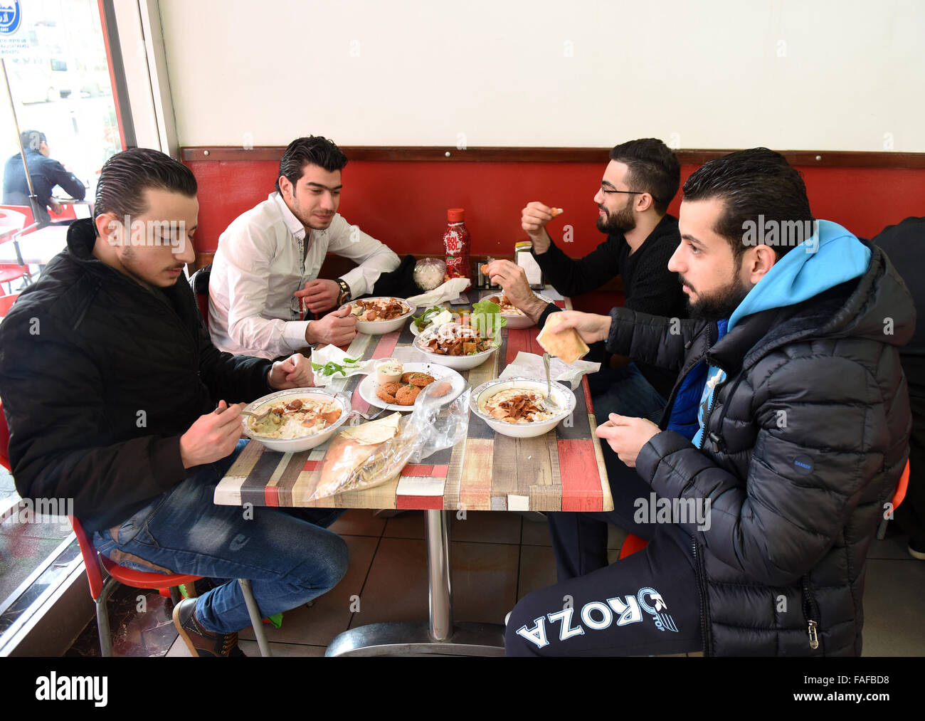 (151229) -- ISTANBUL, le 29 décembre 2015 (Xinhua) -- les gens mangent au restaurant arabe dans un district de Fatih, Istanbul, Turquie, le 22 décembre 2015. À première vue Istanbul's busy Street dans le quartier de Findikli Fatih ne semble pas être différent des autres dans des quartiers de classe moyenne. Mais avec un regard plus profond, on peut remarquer que les enfants ici sont en fait la mendicité en arabe. Restaurant et boutique Panneaux, étiquettes de prix et même en dehors de l'agent immobilier annonces bureaux sont tous en arabe. Les refuges, les syriens fuyant leur pays déchiré par la guerre avec des souvenirs amers de la guerre et perdu des êtres chers, ont essayé de recommencer ici. T Banque D'Images