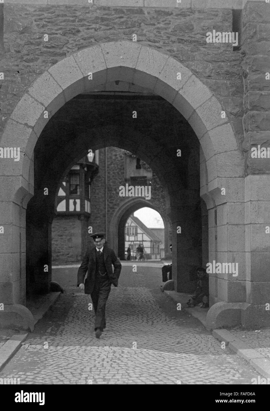 Ein Aufseher läuft durch den Torbogen von Schloss Burg bei Köln, Deutschland 1920er Jahre. Un gardien marche à travers l'arcade de Schloss Burg château près de Solingen, Allemagne 1920. Banque D'Images