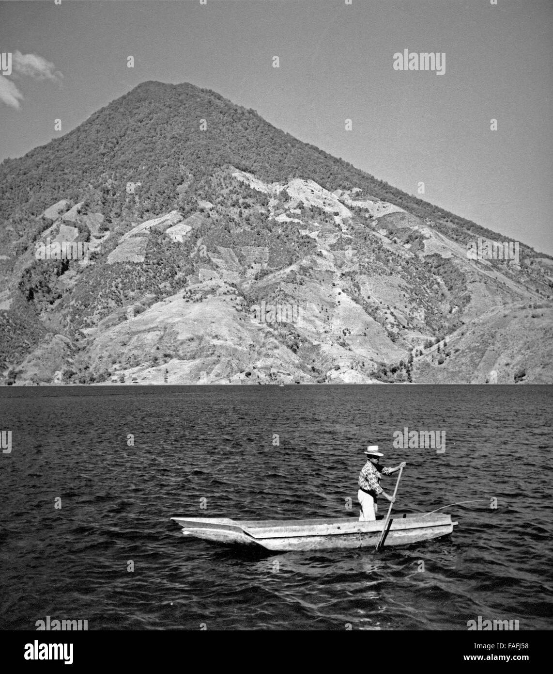 Ein Mann rudert auf dem Lago Atitlan, Guatemala 1970 er Jahre. Un homme de l'aviron sur le lac Atitlan, Guatemala 1970. Banque D'Images
