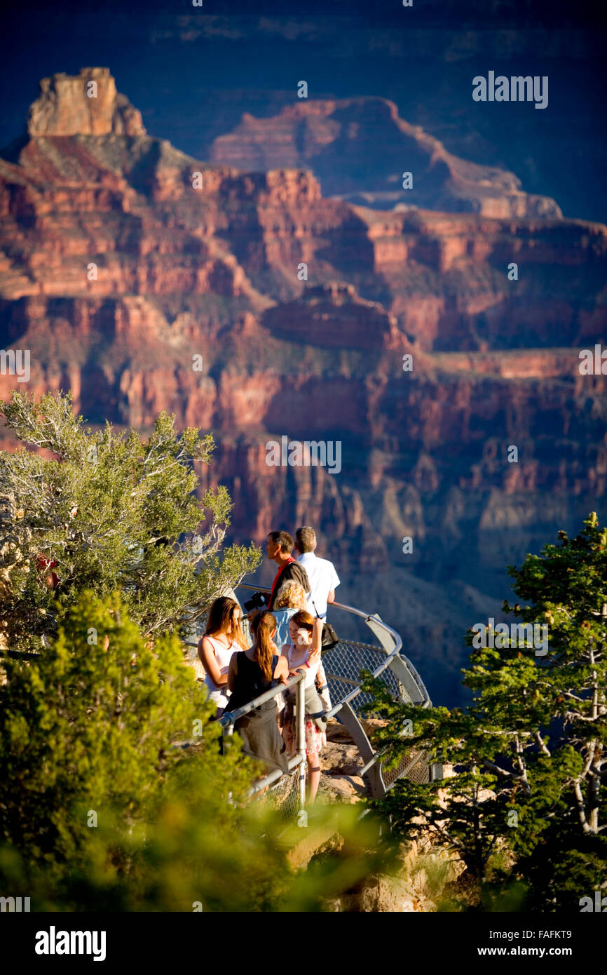 Les personnes à la recherche à la vue du grand canyon à partir d'un affût au lever du soleil. Banque D'Images