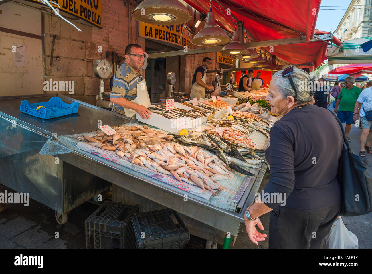Marché de poissons de la Sicile, dans le marché aux poissons à Ortigia Ortigia) une femme sicilienne ressemble à un écran de poissons frais, Syracuse (Syracuse), en Sicile. Banque D'Images