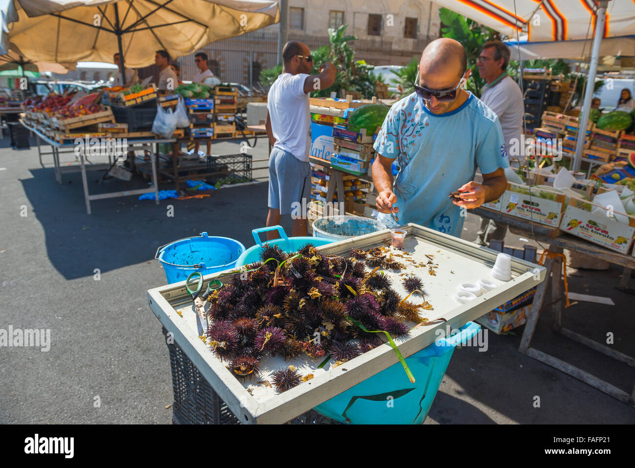 Marché aux poissons de la Sicile, vue d'un commerçant avec un plateau d'oursins de mer fraîchement pêchés à la vente sur le marché aux poissons, sur l'île d'Ortygie à Syracuse, en Sicile. Banque D'Images
