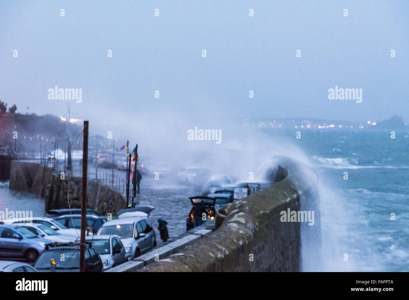 Mousehole, Cornwall, UK. 29 décembre 2015. Météo britannique. 2 heures avant la marée haute. Storm Frank hits Mousehole, poussant les vagues sur le port, l'envahissement des murs des voitures en stationnement de visiteurs qui sont venus pour voir les lumières de Noël. Crédit : Simon Yates/Alamy Live News Banque D'Images