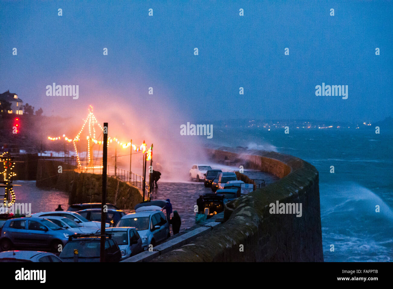 Mousehole, Cornwall, UK. 29 décembre 2015. Météo britannique. 2 heures avant la marée haute. Storm Frank hits Mousehole, poussant les vagues sur le port, l'envahissement des murs des voitures en stationnement de visiteurs qui sont venus pour voir les lumières de Noël. Crédit : Simon Yates/Alamy Live News Banque D'Images