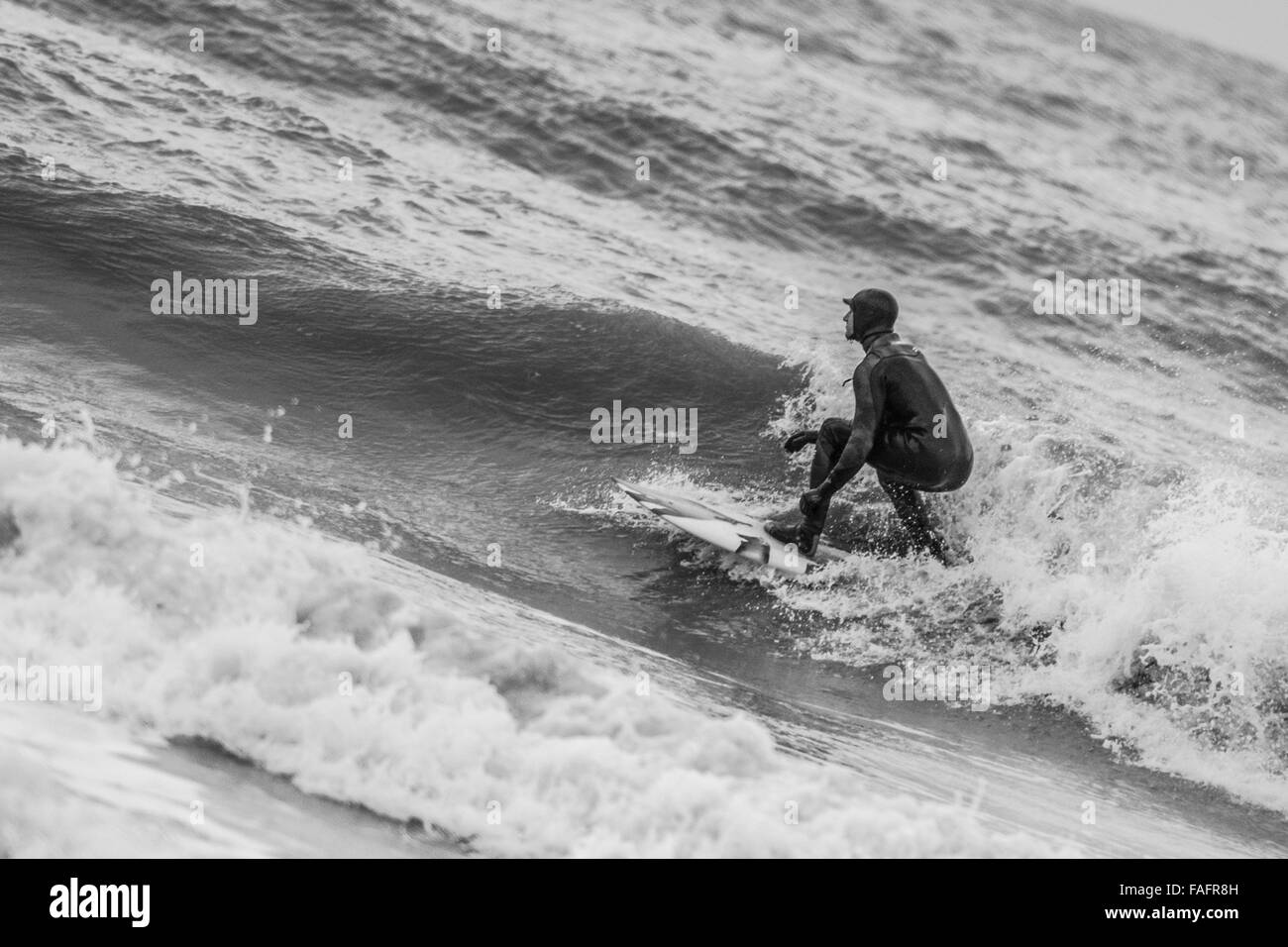 Un surfeur au large de la côte ouest du pays de Galles profite d'une pause dans la tempête Frank Banque D'Images