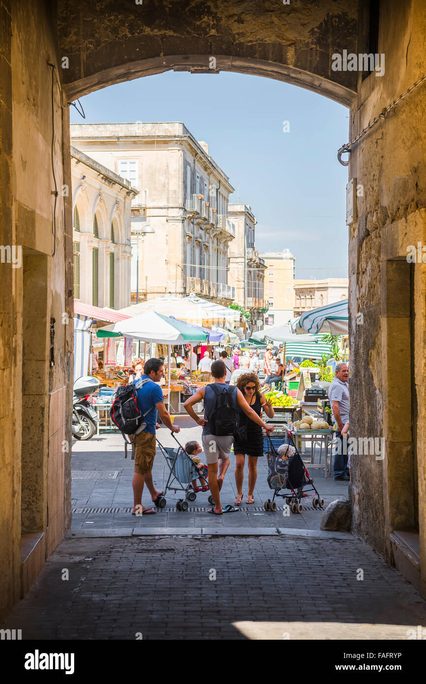 L'Italie, la famille des parents avec leurs enfants au cours de la conversation d'un voyage d'achats au marché à Syracuse, en Sicile. Banque D'Images