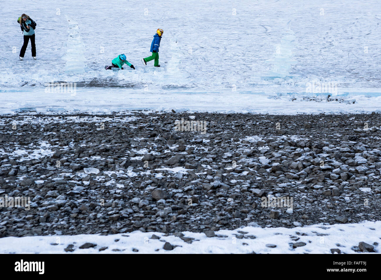 Kandersteg, Suisse. 29 Décembre, 2015. Les marcheurs et patineurs sur glace sur le lac gelé Oeschinen 'l'Oeschinensee'. Le lac est généralement gelé pendant cinq mois, de Décembre à Mai. Grâce au manque de précipitations cet hiver, la glace reste à l'écart de la neige qui est aussi appelé 'black ice' et est accessible aux patineurs et promeneurs. Credit : Dominic Steinmann/Alamy Live News Banque D'Images