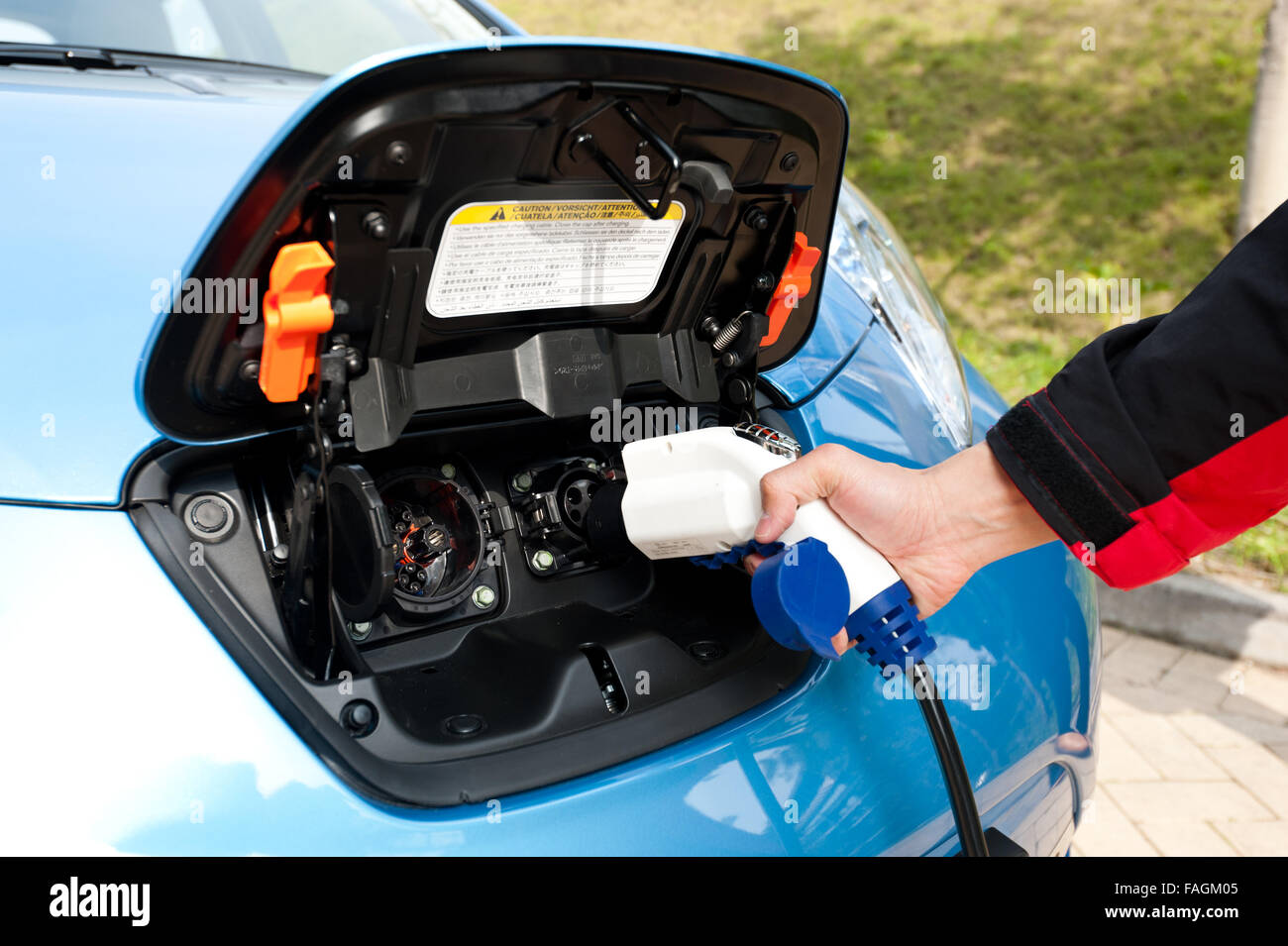 Point de recharge avec prise et cordon d'alimentation pour les voitures électriques et hybrides. L'accent sur le bouchon Banque D'Images