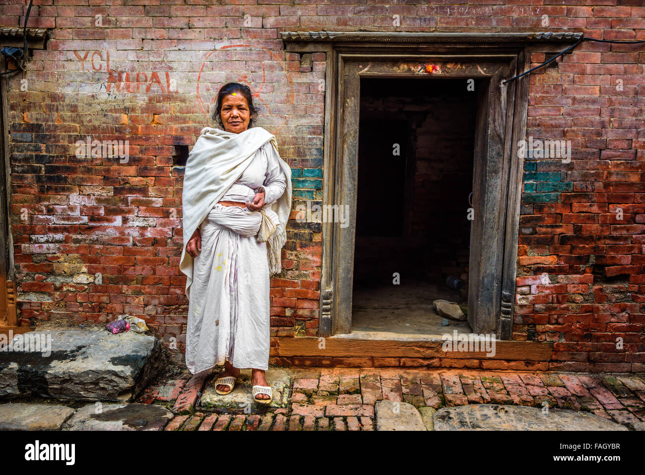 Vieille dame se tient juste en face de sa maison à Katmandou Banque D'Images