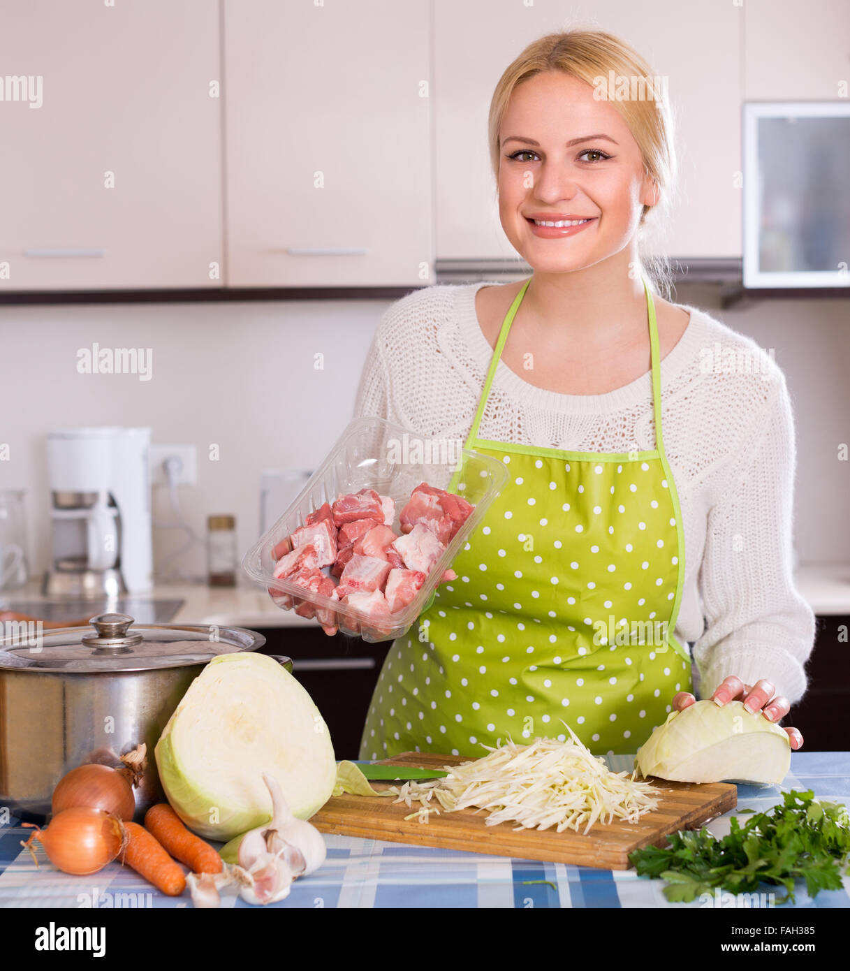 Jeune femme au foyer de ragoût de viande avec chou râpé à l'intérieur Banque D'Images