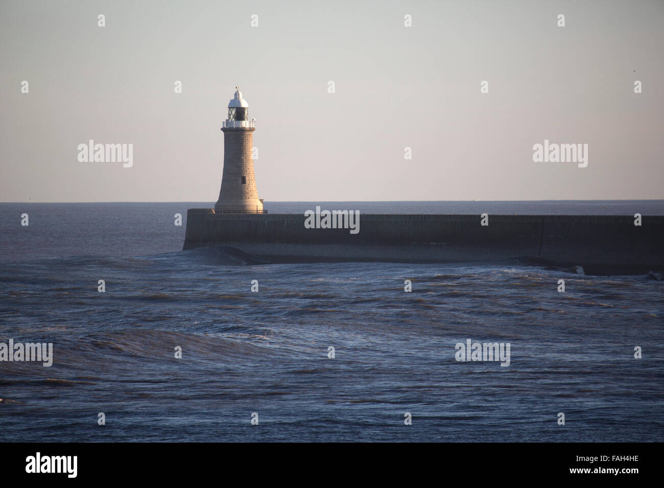 La jetée et phare de Tynemouth, en Angleterre. La mer du Nord tours contre la jetée. Banque D'Images