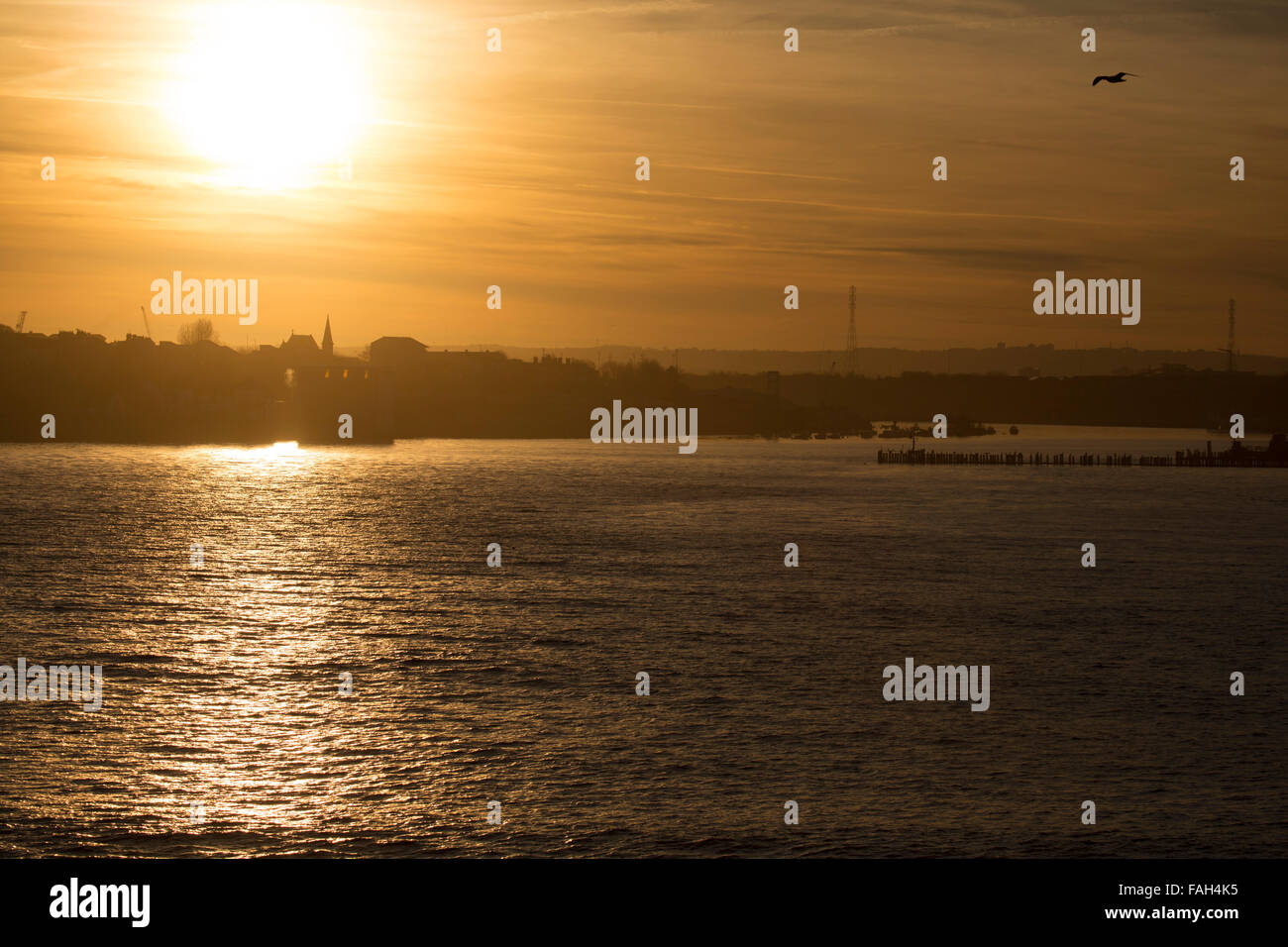 Coucher du soleil sur la rivière Tyne et de la ville de South Shields en Angleterre. Le faible soleil donne le ciel d'une teinte dorée. Banque D'Images