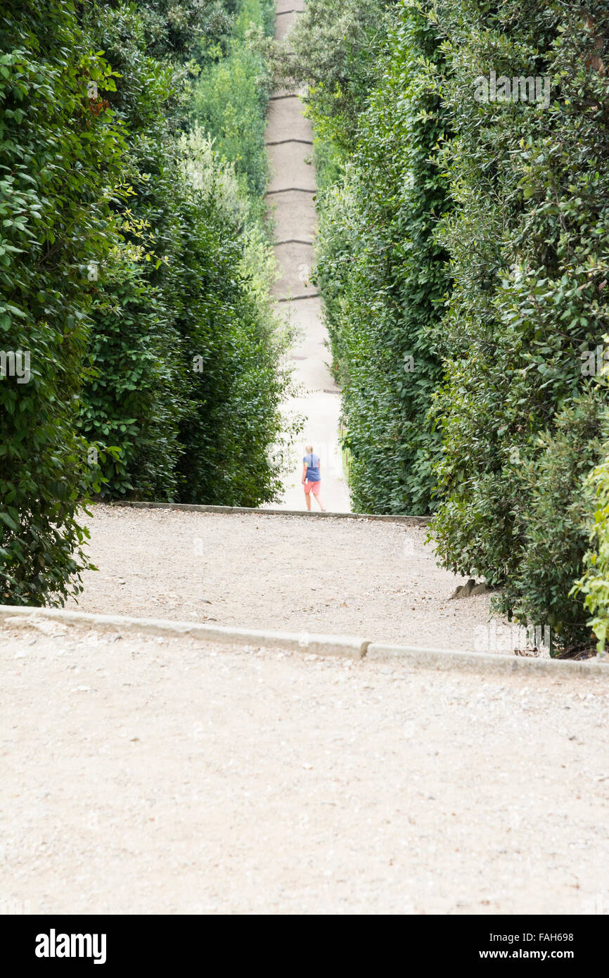 Italy-August,26,2014:un homme solitaire erre sur un chemin à l'intérieur des jardins de Boboli pendant une journée nuageuse. Banque D'Images