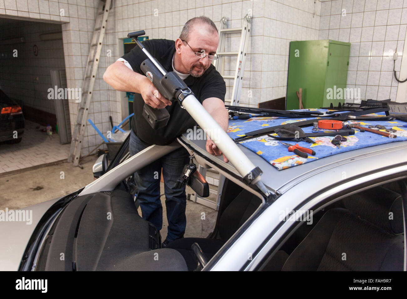 Remplacer le pare-brise dans un atelier de verre automobile. Banque D'Images