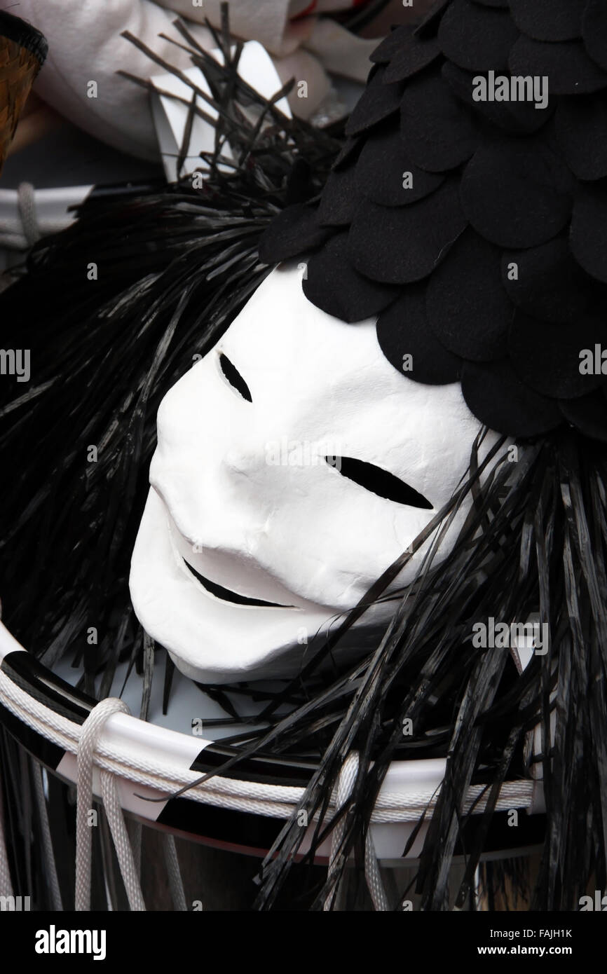 Un seul masque de carnaval de Bâle, montrant un visage de clown noir et blanc avec chapeau portant sur le dessus d'une caisse claire. Banque D'Images