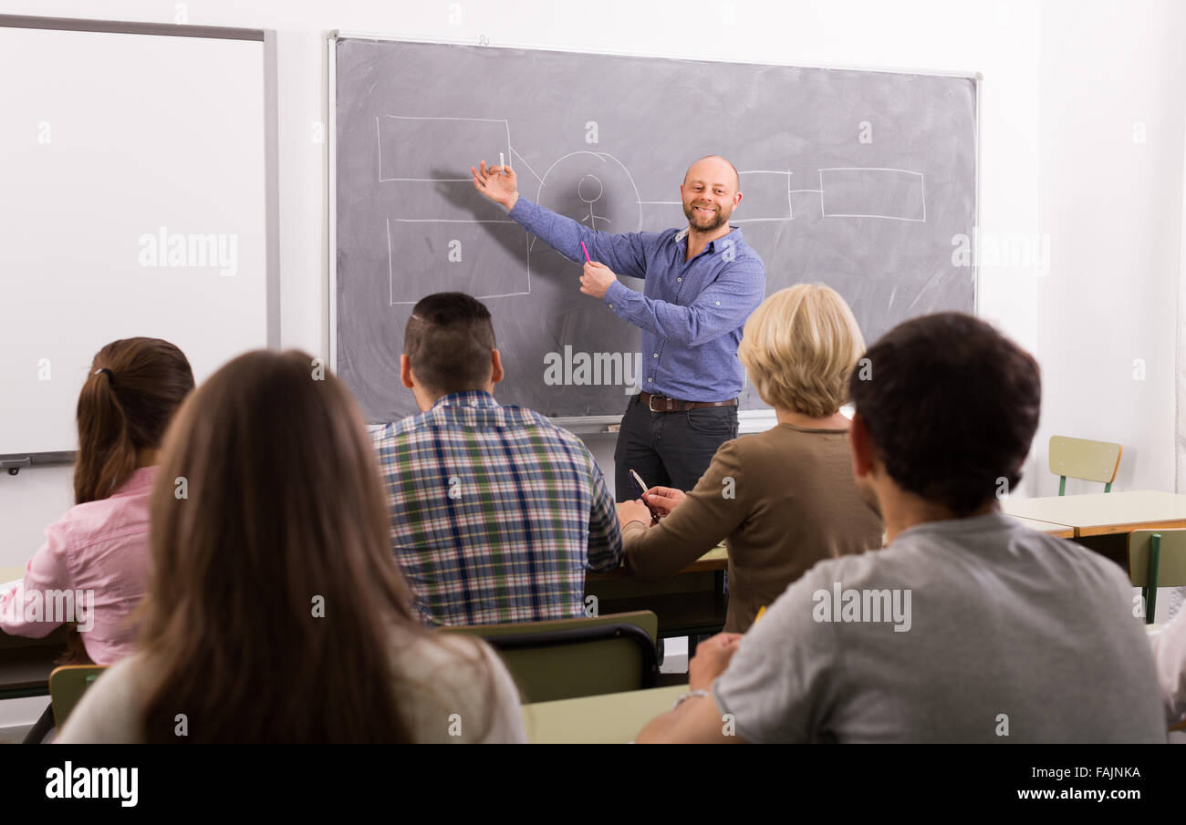 Les étudiants adultes attentifs en classe avec l'enseignant Banque D'Images