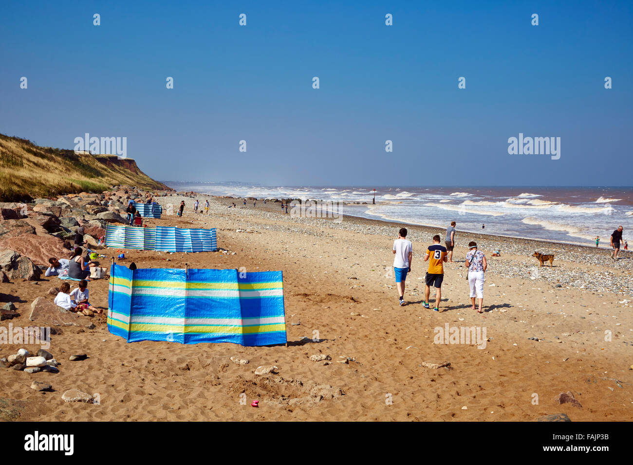 Les familles bénéficient d'un jour de septembre derrière de brise-vent sur Mappleton Beach avec une brise de mer sur une journée ensoleillée. L'espace de copie pour le texte Banque D'Images