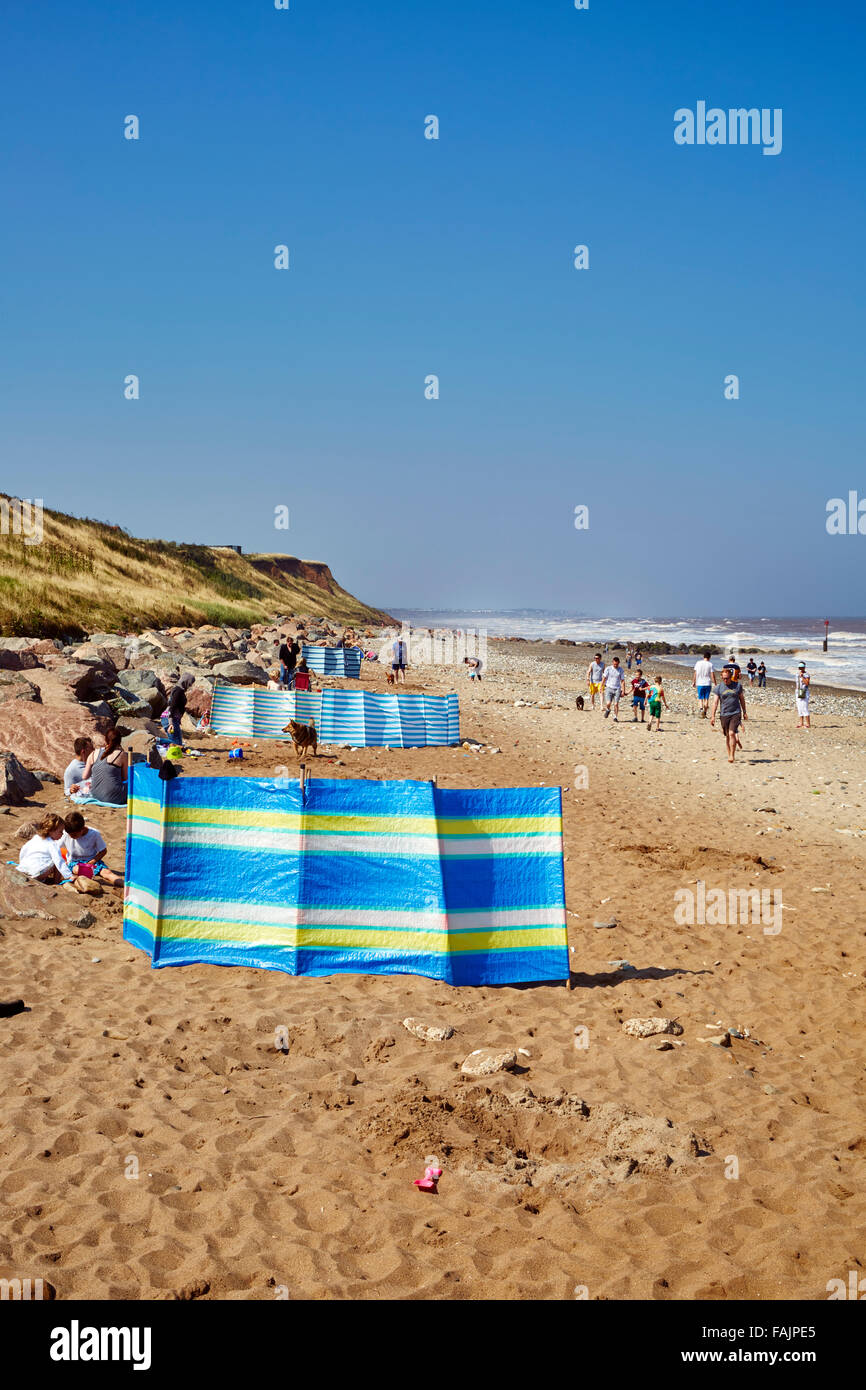 Les familles bénéficient d'un jour de septembre derrière de brise-vent sur Mappleton Beach avec une brise de mer sur une journée ensoleillée. L'espace de copie pour le texte Banque D'Images