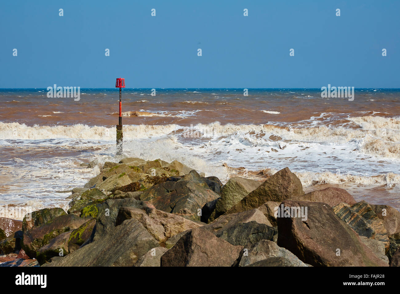 Une légère brise de mer agitée dans de petites vagues contre les rochers sur la plage Mappleton copie espace pour le texte Banque D'Images