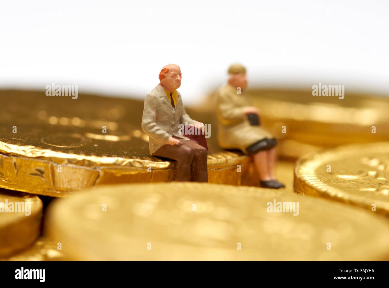Des gens assis sur le chocolat miniatures pièces argent Banque D'Images