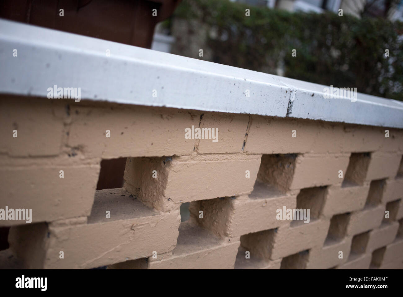 Jardin avant à motifs en brique, mur peint marron clair et blanc. Banque D'Images