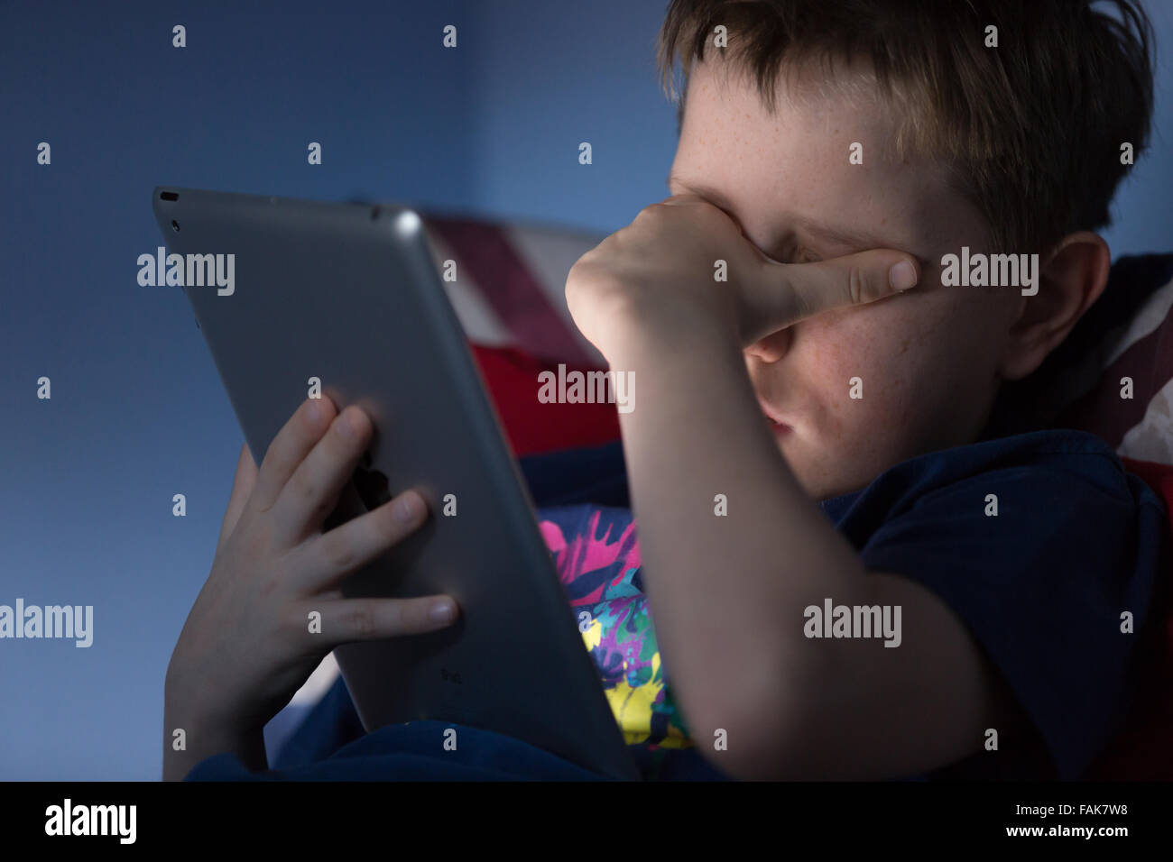 L'intimidation en ligne cyberintimidation photo d'un garçon perturbé dans sa chambre à la recherche de messages blessants sur les médias sociaux Banque D'Images