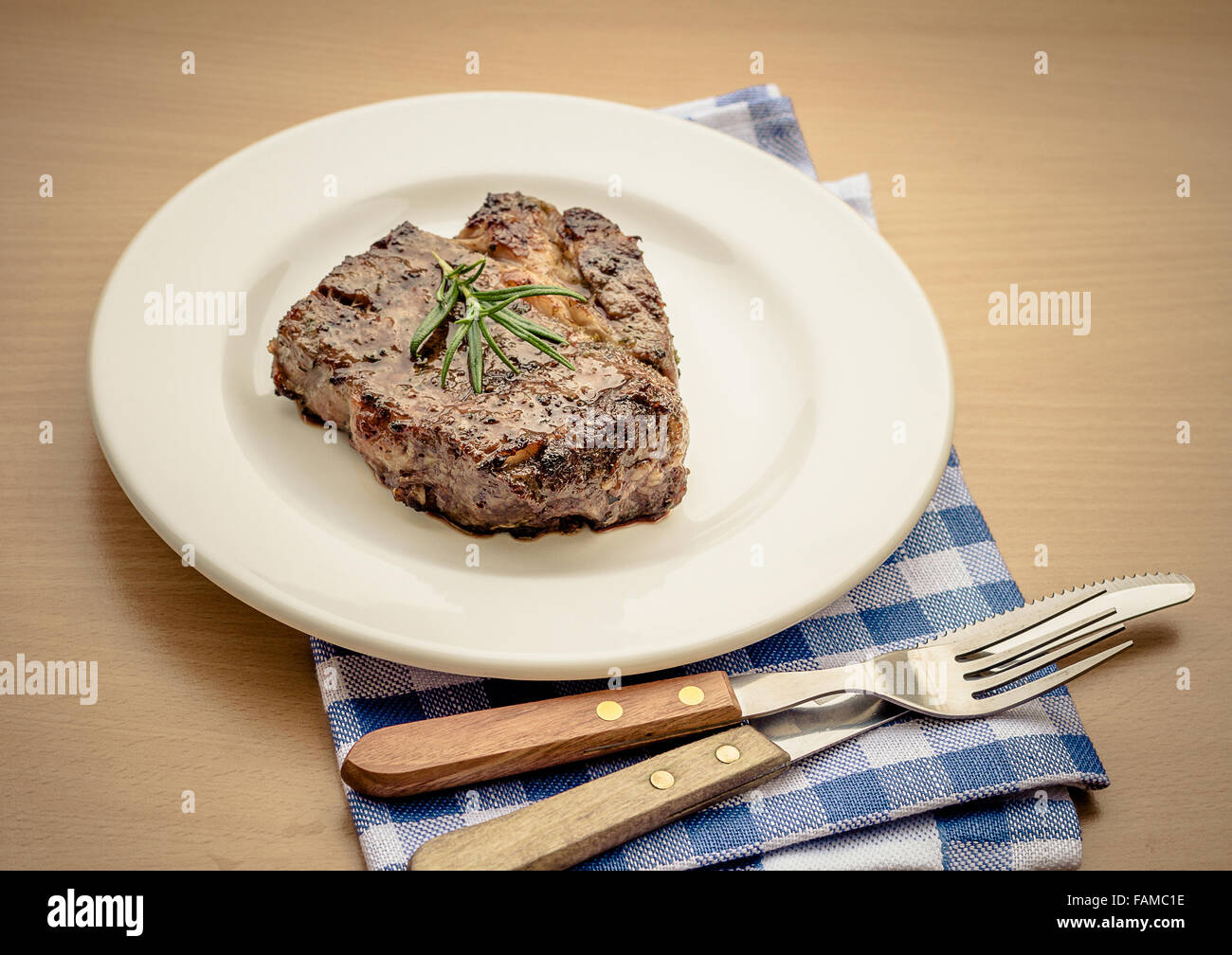 Bifteck de faux-filet grillé juteux avec couverts, aux tons rétro Banque D'Images