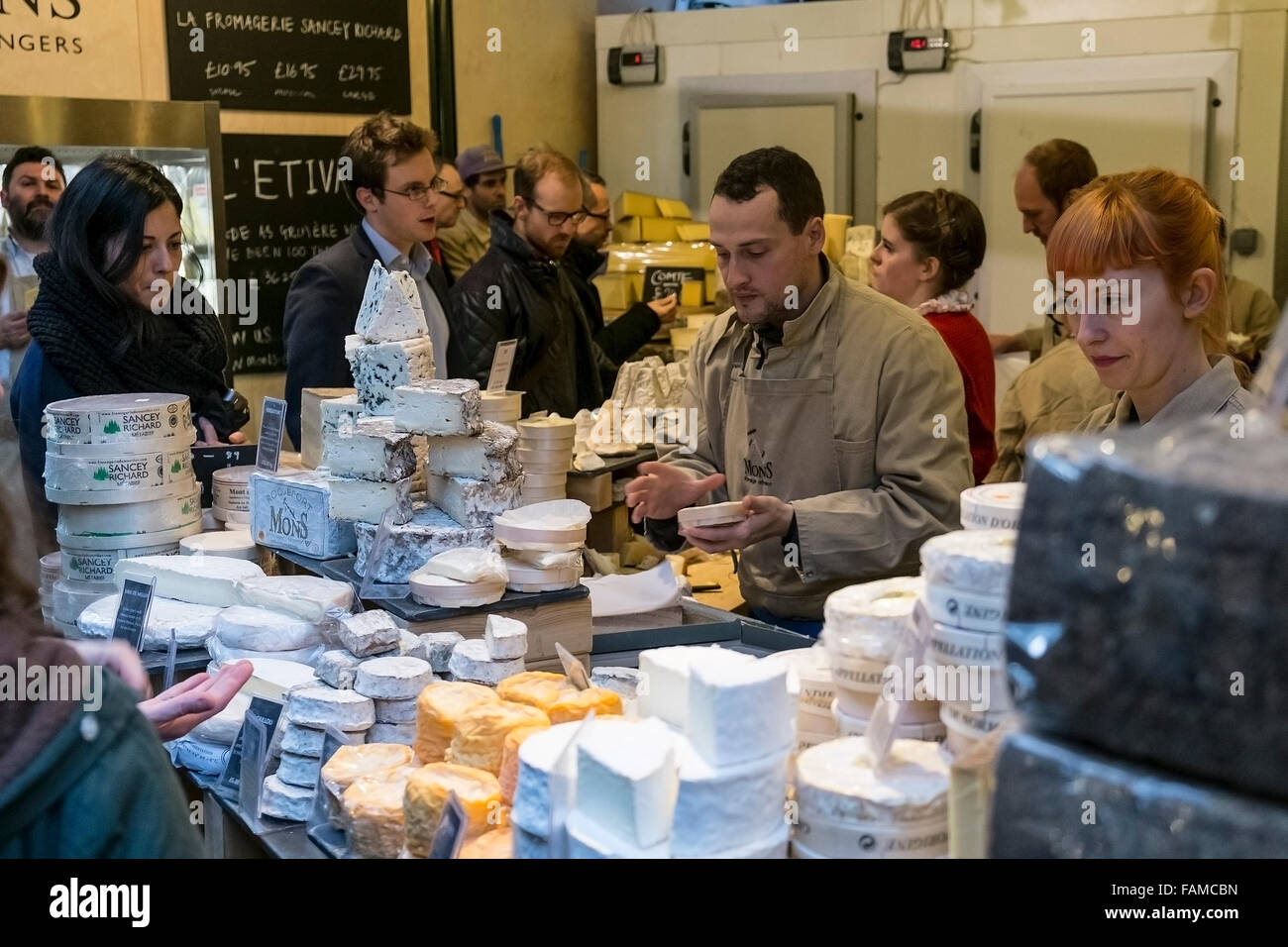 Les clients qui achètent des fromages au Borough Market à Londres. Banque D'Images