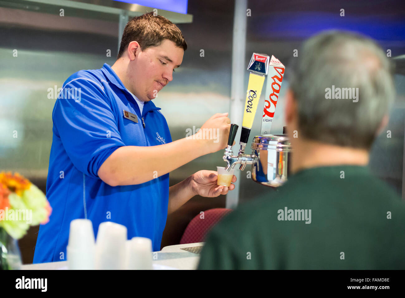 Golden, Colorado - La Brasserie Coors. Un guide verse des échantillons de bière Coors pour les membres d'un groupe touristique. Banque D'Images