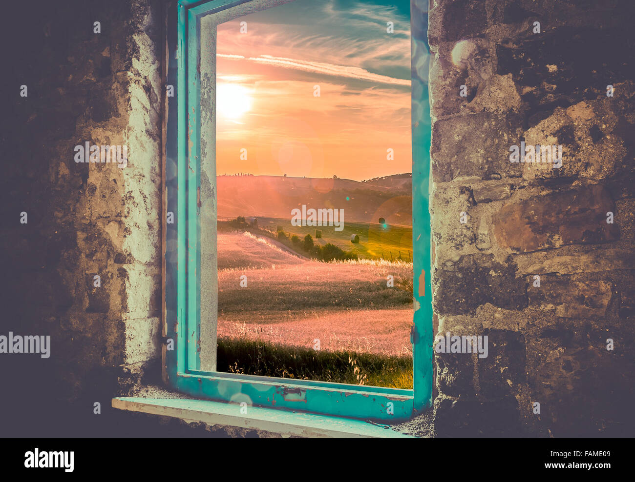 Vieille fenêtre cassée et coucher de soleil sur les collines toscanes Banque D'Images