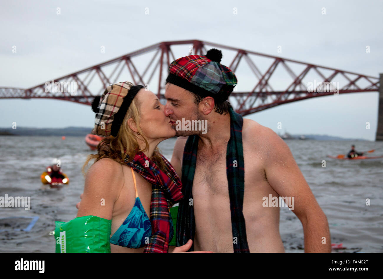 South Queensferry, Edinburgh, Scotland UK. 01 janvier 2016. Queensferry Loony Dook, les plongeant dans la rivière Forth à l'ombre de la célèbre Forth Rail Bridge. A lieu le troisième jour de l'Edinburgh Hogmany célébrations du Nouvel An. Le temps était froid mais juste entre 2 à 4 degrés, mais ce n'a pas refroidi les esprits de ces hardis participants. Banque D'Images