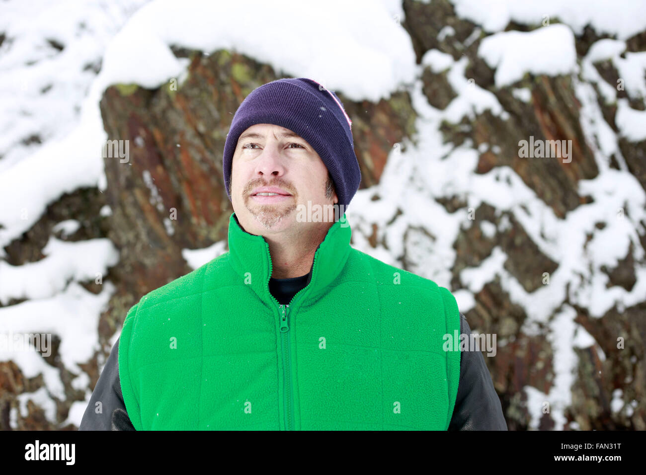 Man et au-delà, dans une scène d'hiver avec les roches montagneuses couvertes de neige dans l'arrière-plan. Banque D'Images