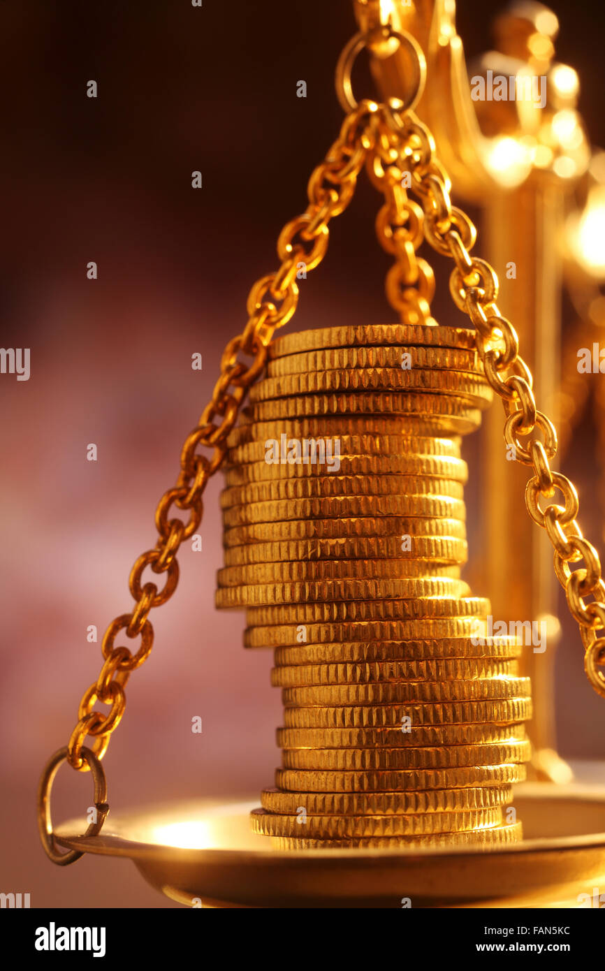 Des piles de pièces d'or brillant brillant placé sur une balance Banque D'Images