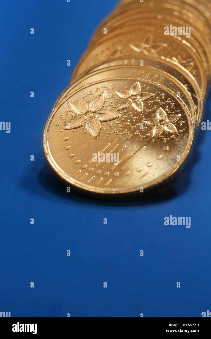 Close up des pièces d'or piles dans une rangée Banque D'Images