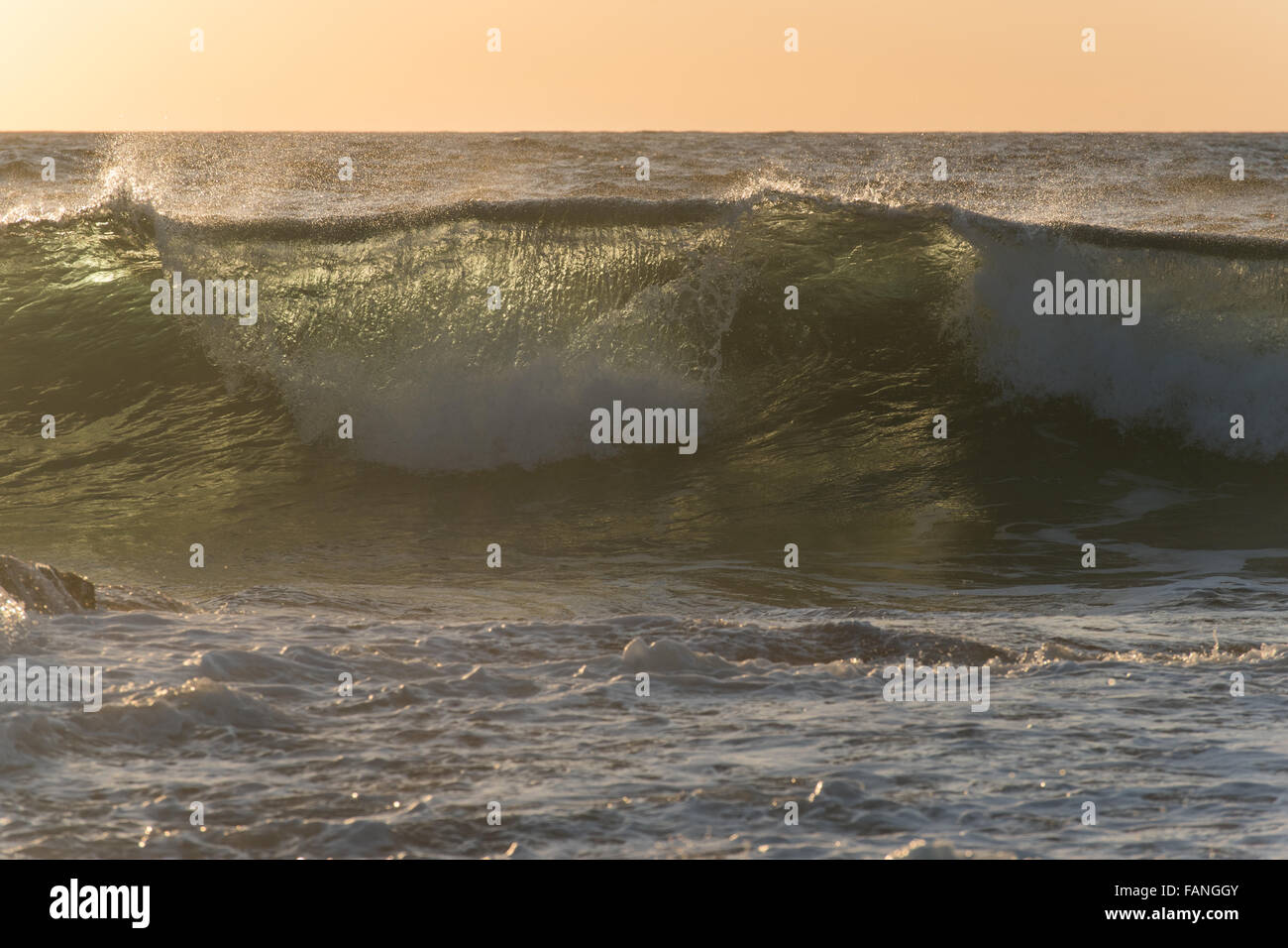 Les grandes vagues de l'océan transparent au lever du soleil, avec rétroéclairage et la couleur verte Banque D'Images