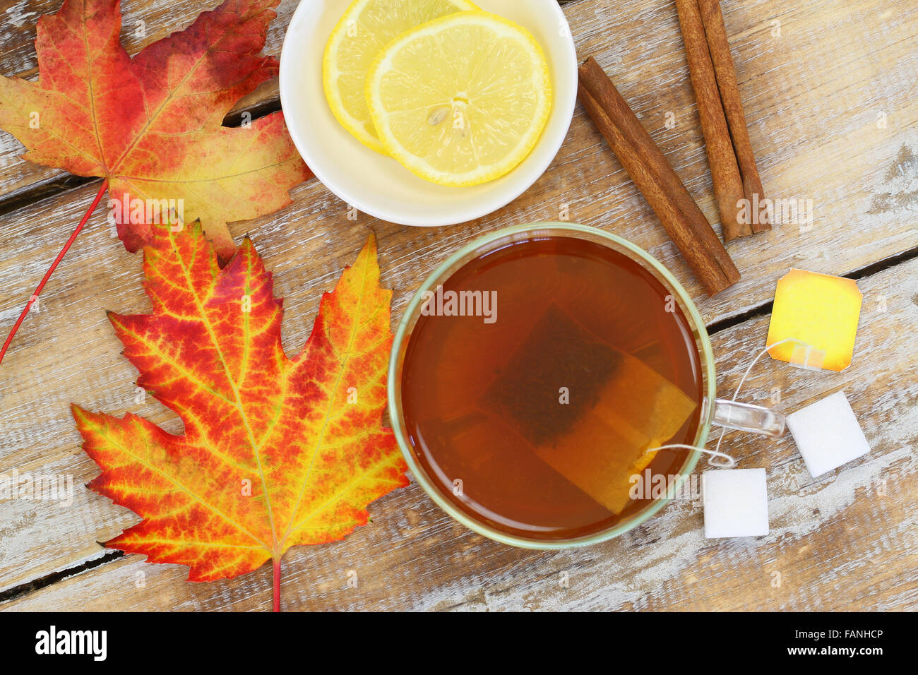 Thé, feuille d'automne, le citron, l'anis étoilé et la cannelle sur bois rustique Banque D'Images