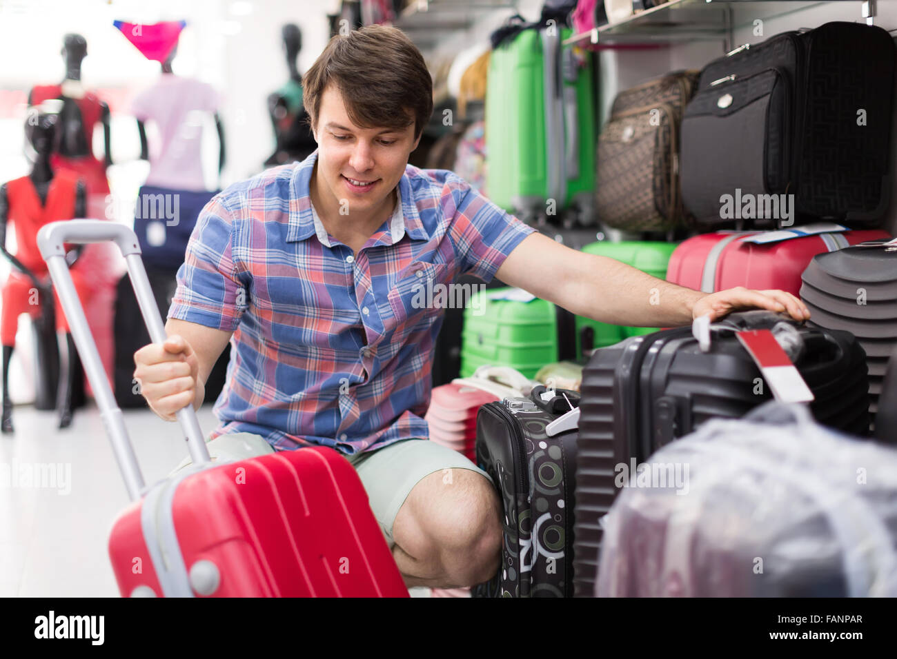Jeune homme souriant positives l'achat de voyage par store Banque D'Images