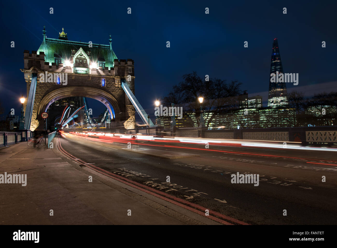 London Tower Bridge, UK, de nuit avec des voitures et bus en laissant des traces de lumière colorée. Banque D'Images