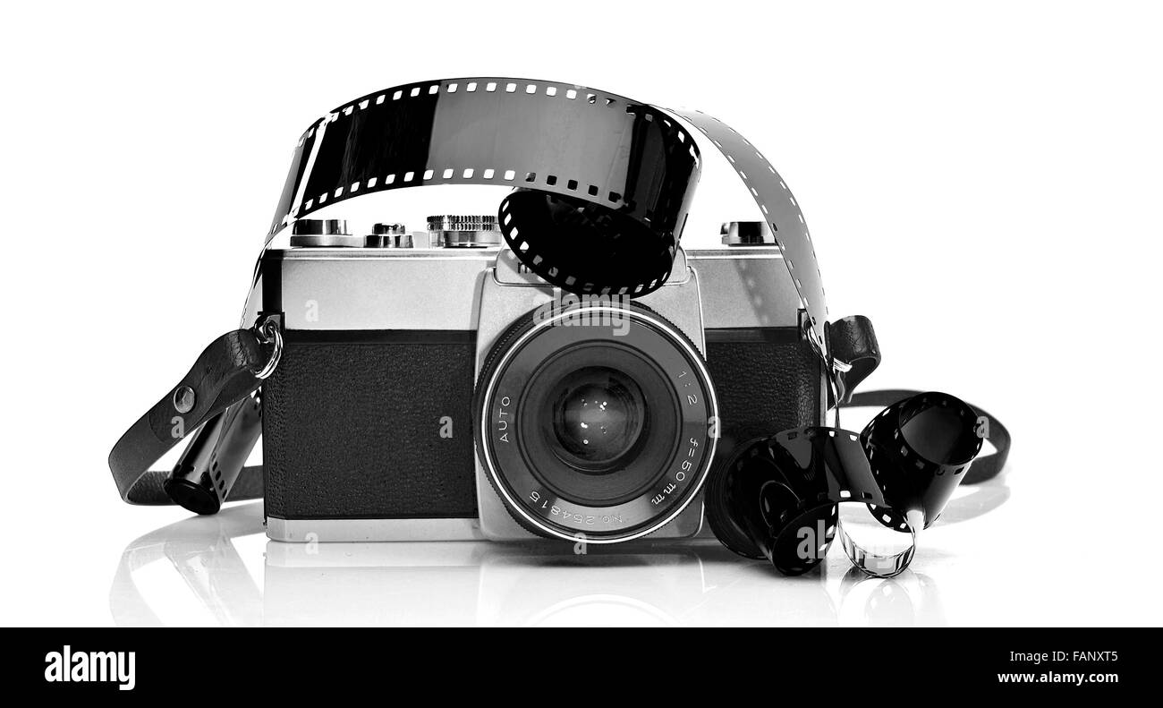Ancien appareil photo de film de 35mm sur fond blanc avec bande de film 35 mm Banque D'Images